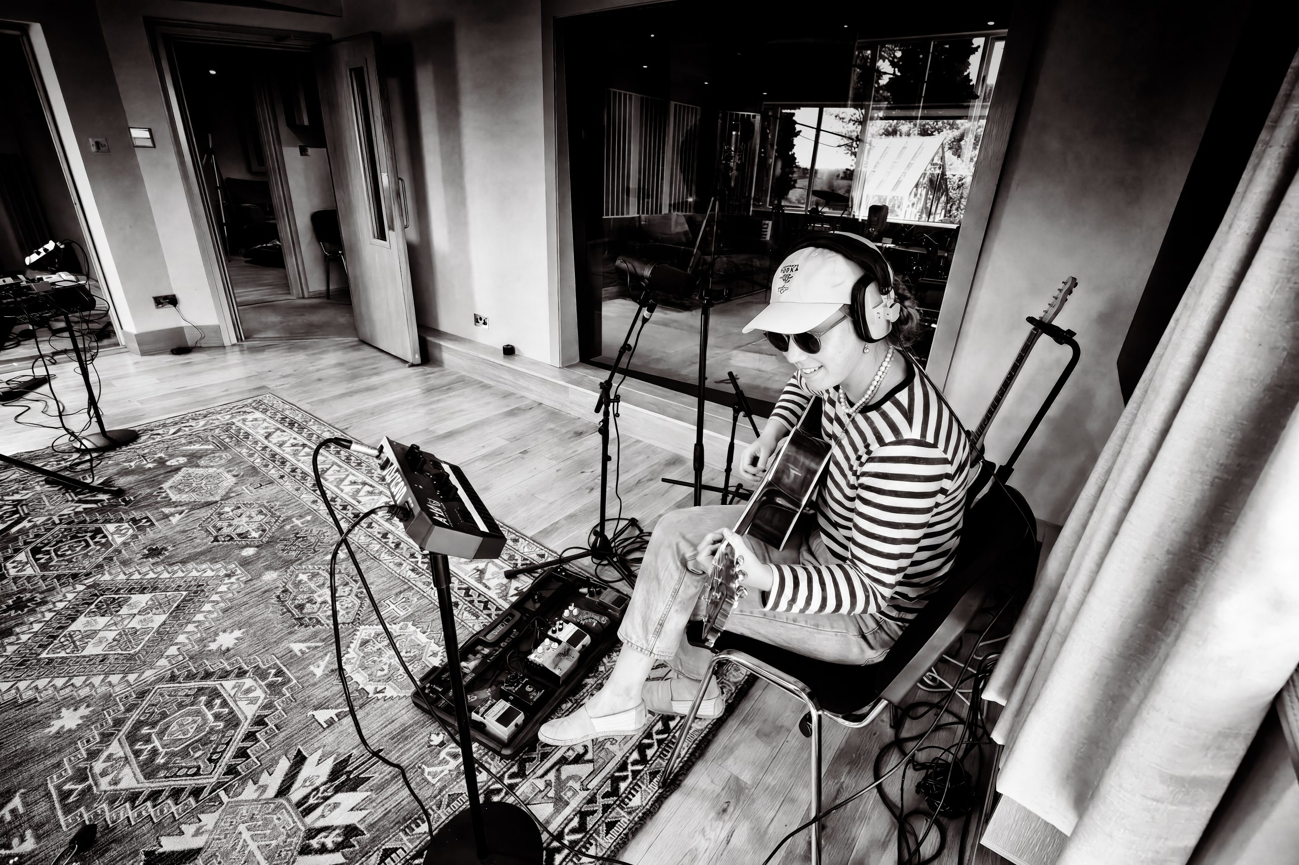 A guitarist recording in the live room